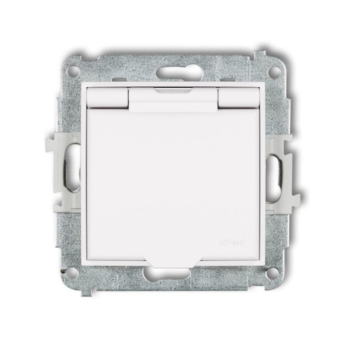 Gniazdo bryzgoszczelne Karlik MINI z uziemieniem, w kolorze białym matowym. Produkt z klapką, widoczny z przodu, zamontowany w metalowej ramie. Oznaczenie IP44 dla ochrony przed wilgocią. Idealne do użytku w trudnych warunkach.