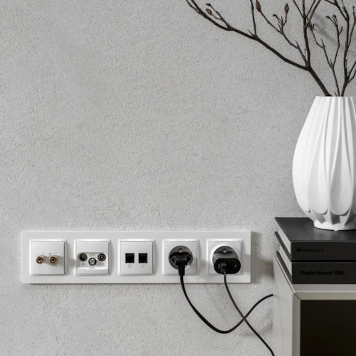 Gniazdo antenowe Simon 10 SAT-SAT-RTV w kolorze białym, montowane w ścianie. Widoczne dwa złącza antenowe, gniazdo RJ45 oraz dwa gniazda elektryczne. Produkt zainstalowany na jasnej, teksturowanej ścianie, z przewodami podłączonymi do gniazd.