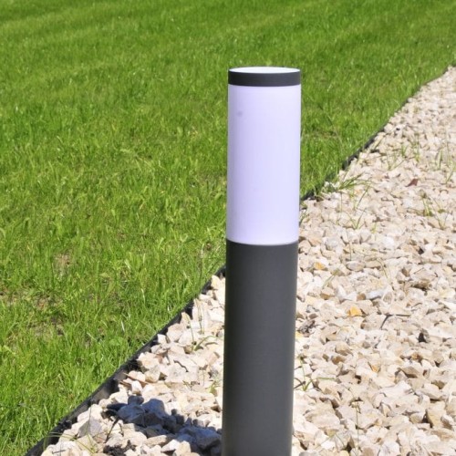 Klosz do lampy Oslo Goldlux 305220 w kształcie cylindrycznym, z białą górą i szarym dolnym segmentem. Ustawiony pionowo na tle trawnika i kamieni ozdobnych, podkreślający nowoczesny design oświetlenia zewnętrznego.