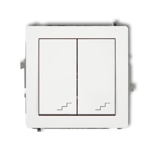 Podwójny łącznik schodowy Karlik Deco w kolorze białym. Posiada dwa przyciski z graficznymi oznaczeniami schodów. Ujęcie frontalne, produkt montowany na ścianie, z widocznymi zaczepami po bokach.