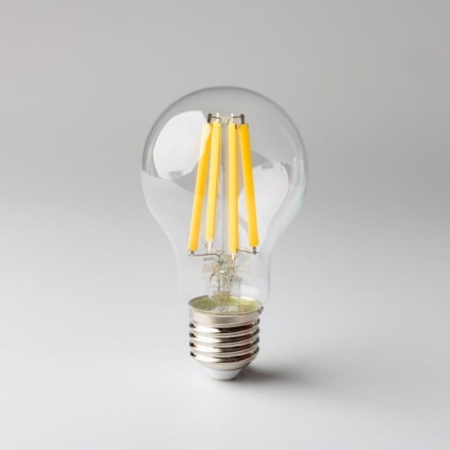 Żarówka LED filament E27 10W ciepła biała z przezroczystą bańką. Wewnątrz widoczne cztery żółte filamenty. Gwint E27, stojąca na białym tle, o klasycznym kształcie.