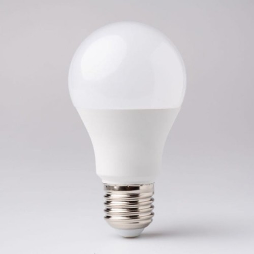 Żarówka LED E27 10W z zimną białą barwą światła. Okrągła, biała obudowa z przezroczystą kopułą, metalowy gwint. Ujęcie frontalne, produkt stoi na płaskiej powierzchni, na jednolitym tle.