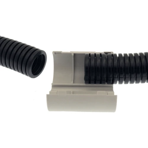 Złączka zatrzaskowa ZZCR-20 w kolorze szarym, widoczna w pozycji leżącej. Produkt ma otwór do podłączenia czarnej, falistej rury. Wewnątrz złączki widoczne są pierścienie, które zapewniają szczelność połączenia. Tło białe.