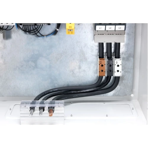 Złączka STB 95 w kolorze niebieskim, przeznaczona do przewodów AL/CU o przekroju 16-95 mm², zamontowana w obudowie elektrycznej. Widoczne przewody łączące złączkę z innymi elementami instalacji.