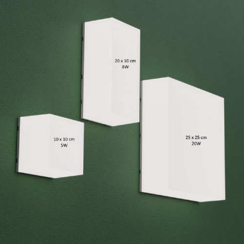 Oprawa sześcienna SCATOLLO 20W 230V IP54 w kolorze białym, o wymiarach 250x250x75 mm, zamontowana na zielonej ścianie. Widoczne trzy warianty opraw o różnych rozmiarach i mocach.