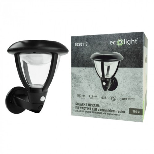 Lampa solarna elewacyjna SOE-3 w kolorze czarnym, z przezroczystym kloszem i czujnikiem ruchu. Produkt zamontowany na ścianie, z opakowaniem obok, zawierającym informacje o specyfikacji. Działa na energię słoneczną, zapewniając oświetlenie LED.