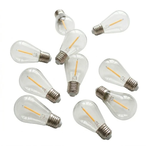 Zestaw 10 żarówek LED Filament E27 o mocy 1W. Żarówki mają przezroczyste klosze, metalowe gwinty oraz widoczny żarnik w kolorze ciepłej bieli. Ułożone w luźny sposób, różne kąty widzenia.