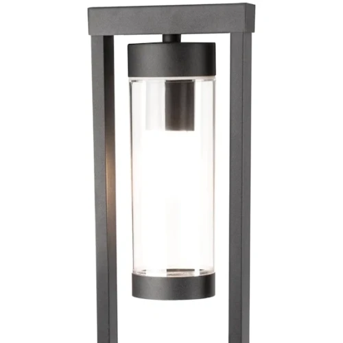 Lampa ogrodowa stojąca SPECTRA o wysokości 80 cm, wykonana z czarnego metalu, z przezroczystym kloszem w formie cylindrycznej. Ujęcie z przodu, pokazujące prostą konstrukcję oraz źródło światła wewnątrz klosza.