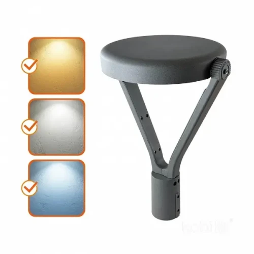 Lampa parkowa KOBI LED NEXPARK G2 z okrągłą, szaro-czarną głowicą, zamontowana na trójnogim stelażu. Wskazania kolorów światła: ciepłe, neutralne i zimne. Wodoodporność IP66, przeznaczona do użytku zewnętrznego.