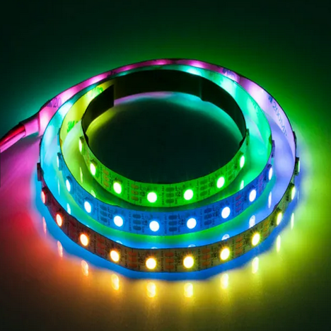 Taśma LED 7,2W w barwie RGB o długości 5m z funkcją muzyczną. Widoczne trzy paski w różnych kolorach: zielonym, niebieskim, żółtym, różowym i czerwonym, ułożone w okrąg. Taśma elastyczna, z widocznymi diodami LED.