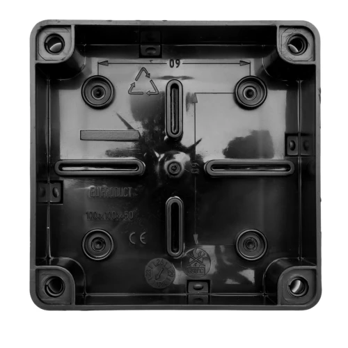 Puszka natynkowa 100x100x50 mm w kolorze czarnym, wykonana z tworzywa, z widocznymi otworami montażowymi oraz oznaczeniami technicznymi. Brak dławików, klasa ochrony IP65. Ujęcie frontalne, widok na wnętrze puszki.