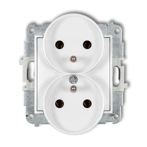 Podwójne gniazdo elektryczne Karlik MINI z uziemieniem w kolorze białym. Produkt ma dwa okrągłe otwory na wtyczki, umieszczone w prostokątnej obudowie metalowej. Widoczna jest również śrubka mocująca. Gniazdo zamontowane w ramce.