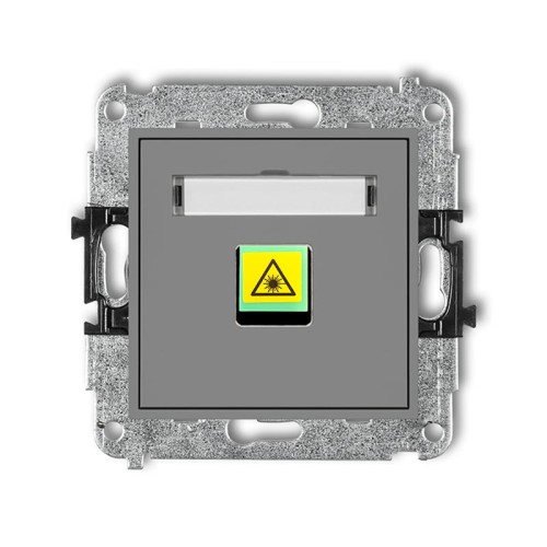 Gniazdo światłowodowe Karlik MINI w kolorze szarym matowym, pojedyncze. Widoczna żółta etykieta ostrzegawcza z symbolem laserowym. Produkt montowany na ścianie, z metalową ramką montażową i otworami do mocowania.