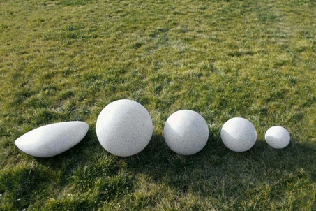 Lampa ogrodowa kula STONO o średnicy 20 cm, wykonana z białego materiału, przypominająca naturalny kamień. Produkt ma okrągły kształt, matową powierzchnię i jest umieszczony na trawie, co podkreśla jego przeznaczenie do użytku zewnętrznego.