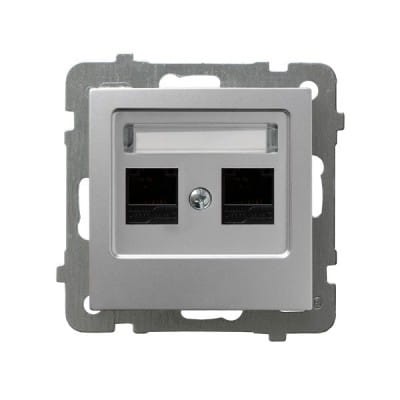 Podwójne gniazdo komputerowe Ospel As w kolorze srebrnym. Zawiera dwa porty Ethernet w czarnych osłonach, umieszczone w metalowej ramce. Gniazdo ma prostokątny kształt i jest montowane na ścianie, z widocznymi otworami montażowymi.